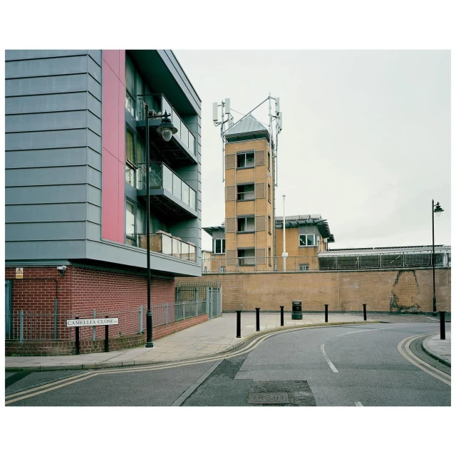 Modern apartment building and communications tower on a city street. Urban scene with contemporary architecture and telecommunications infrastructure.