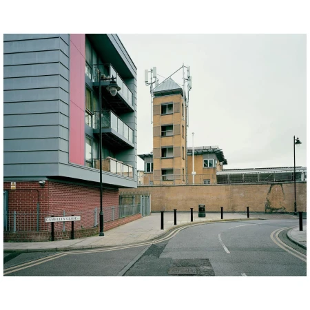Modern apartment building and communications tower on a city street. Urban scene with contemporary architecture and telecommunications infrastructure.