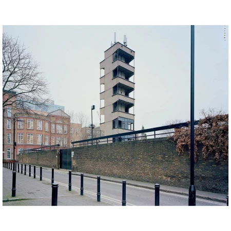 Architectural photograph of a tall concrete building with repetitive balcony elements, captured on a city street on an overcast day.