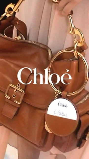 Brown leather Chloe purse with gold hardware and attached coin purse. The bag is held by a person wearing a tan outfit.