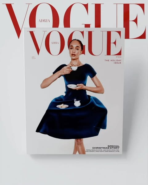 Vogue magazine cover featuring a woman in a blue dress holding a teacup, with red Vogue masthead visible on the cover and in the background.