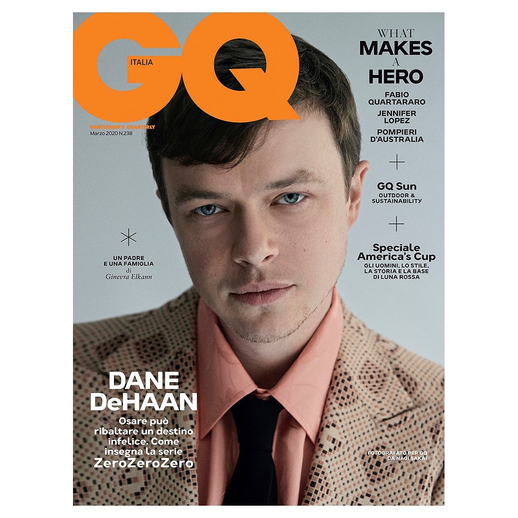 GQ Italia cover featuring Dane DeHaan in a patterned suit, a light orange shirt, and a dark tie. Close-up studio shot with various text elements.