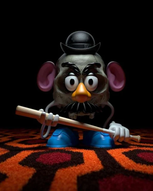 Creepy Mr. Potato Head toy on a patterned carpet and a black background. A wooden stick accentuates the unsettling scene.