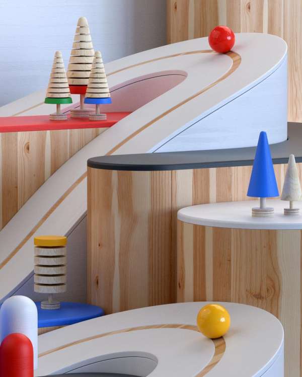 Conceptual set with colorful toy trees, curving platforms, and spheres, creating an abstract architectural scene, shot with studio lighting.
