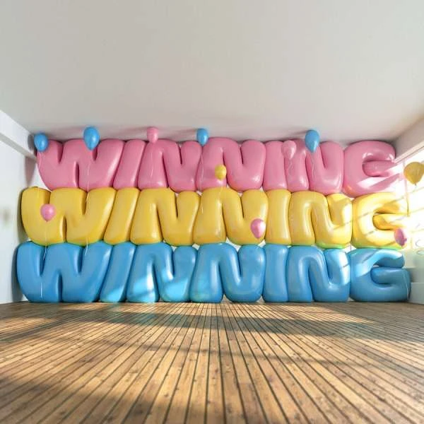 Three rows of balloon letters spelling 'WINNING' in pink, yellow, and blue, with small balloons, on a wood floor in a bright room.