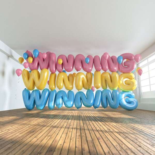 Three rows of balloon letters spelling 'Winning' in pink, yellow, and blue. Balloons also dot the bright white room with a wood floor.