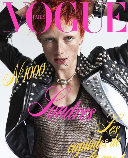 Vogue Paris magazine cover featuring a fair-skinned model with orange hair wearing a studded black jacket and silver chain necklace.
