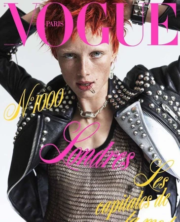 Vogue Paris magazine cover featuring a fair-skinned model with orange hair wearing a studded black jacket and silver chain necklace.