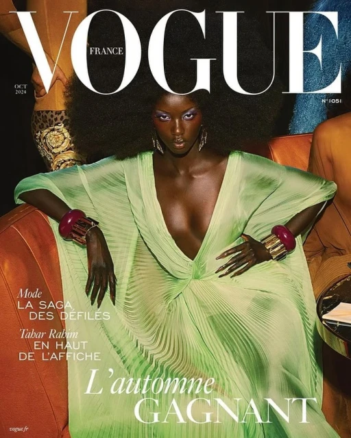 Vogue France magazine cover featuring a Black fashion model with an afro hairstyle wearing a flowing green dress and bold gold jewelry.