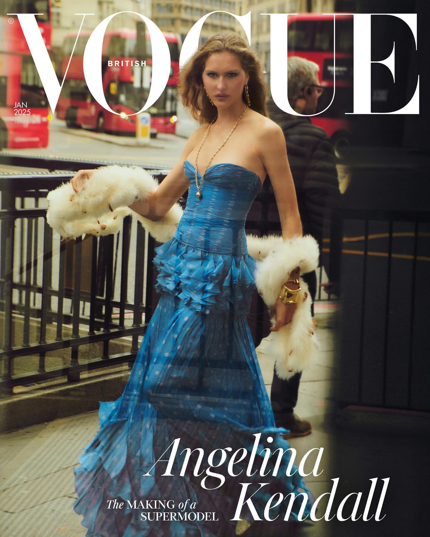 Vogue cover featuring a fashion model wearing a blue dress and faux fur stole, posing on a city street with a double-decker bus in the background.