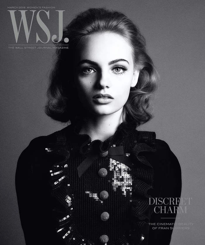 Monochrome fashion magazine cover featuring a woman with dark hair and a black ruffled top by Mikael Jansson.