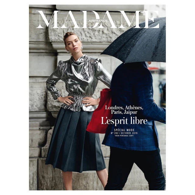Madame Air France magazine cover featuring a stylish woman in a metallic blouse and grey skirt standing next to a man with an umbrella.