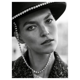Close-up portrait of a woman wearing a dark jeweled hat and textured coat, photographed by Mel Karch.