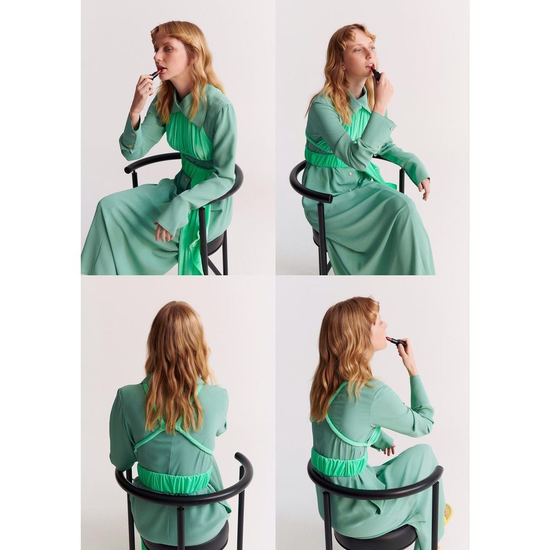 Four views of a blond adult woman in a green dress seated on a black chair, applying lipstick against a plain white background.