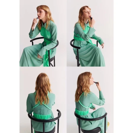 Four views of a blond adult woman in a green dress seated on a black chair, applying lipstick against a plain white background.