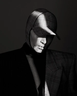 Portrait of a man wearing a plaid cap and matching structured plaid jacket photographed in low-key lighting by Hong Jang Huyn.