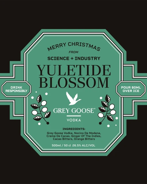 Grey Goose Vodka 'Yuletide Blossom' ad featuring a decorative teal label with holiday messaging on a dark background.