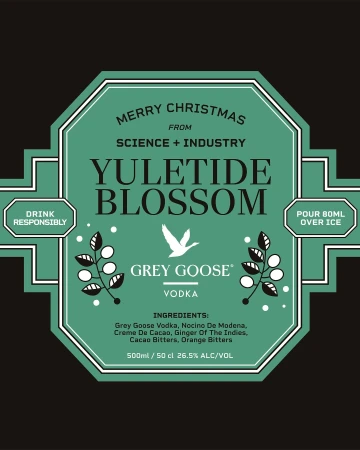 Grey Goose Vodka 'Yuletide Blossom' ad featuring a decorative teal label with holiday messaging on a dark background.