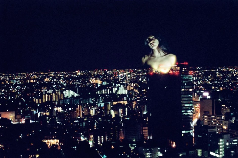 Night cityscape with an ethereal adult female figure merged with the city lights, creating a surreal urban portrait.