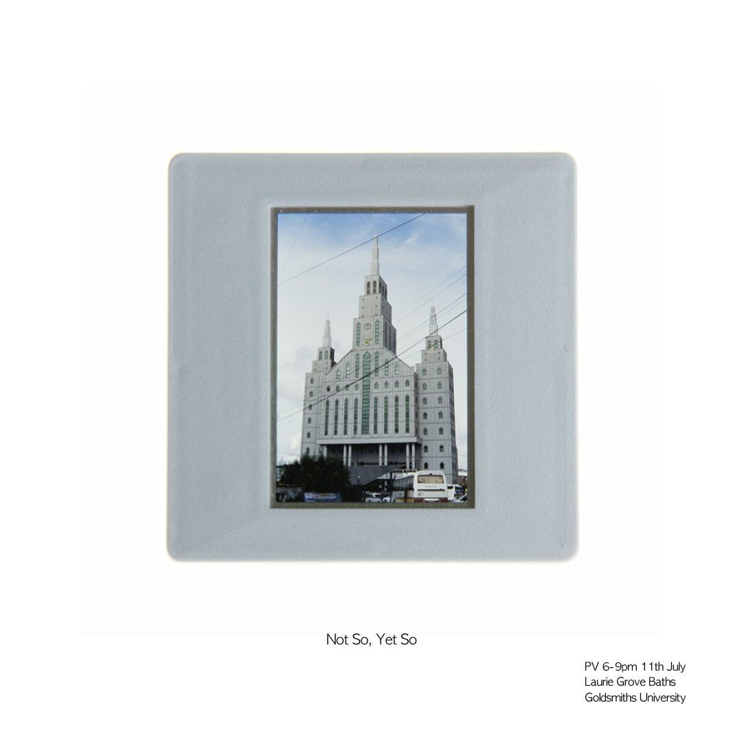 Framed image of a grand building with spires, possibly a cathedral, featuring light blue skies and minimal surrounding foliage.