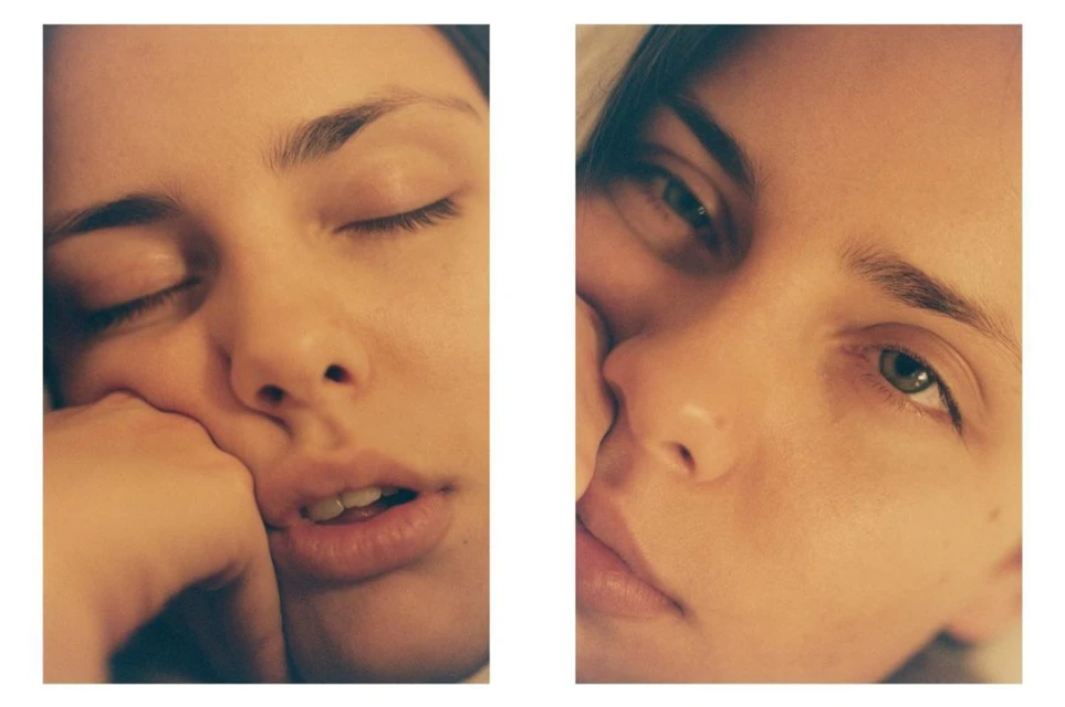 Close-up diptych of a fair-skinned young adult woman, one face with closed eyes, the other with green eyes open, warm, soft lighting.