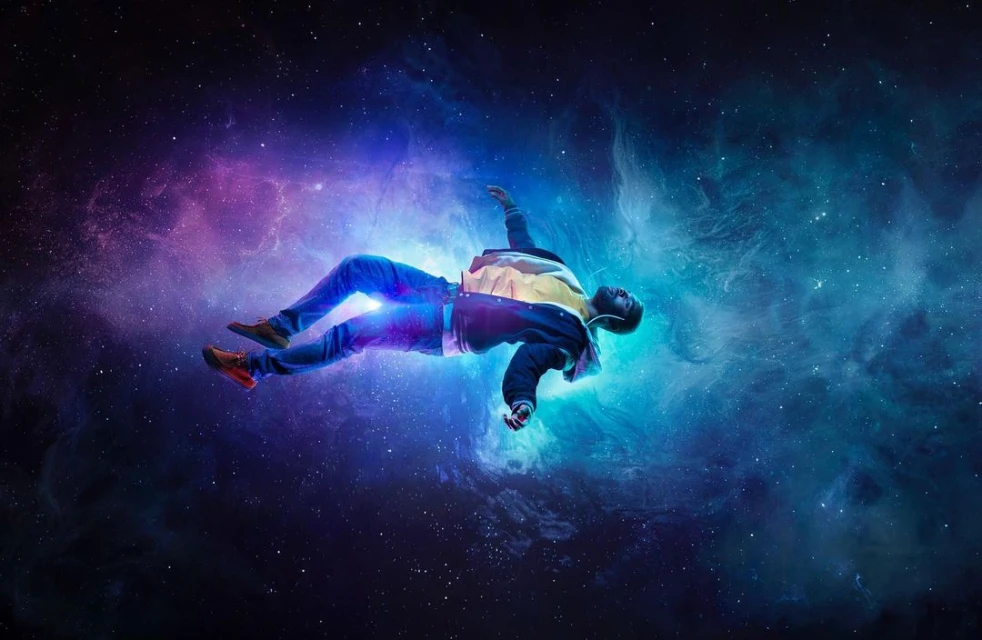 Man floats in space wearing jacket, jeans, and sneakers. Abstract background with purple and blue nebula clouds and scattered stars.
