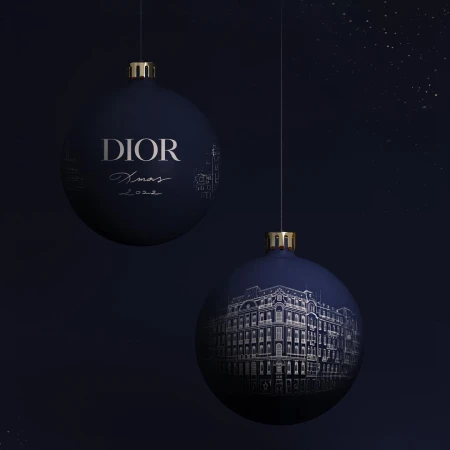 Elegant navy Christmas ornament spheres, suspended against a dark background, display building illustrations and the Dior logo, festive and stylish.