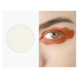 Close-up of a human eye adorned with terracotta orange eye makeup next to a round white product container.