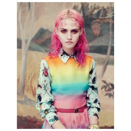 Portrait of a woman with vibrant pink hair wearing a colorful gradient insect-print dress by photographer Elena Rendina.