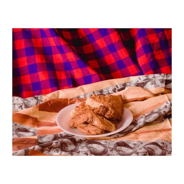 Plate of scones on a patterned tablecloth against a red and purple checkered fabric background. Food photography, rustic style.