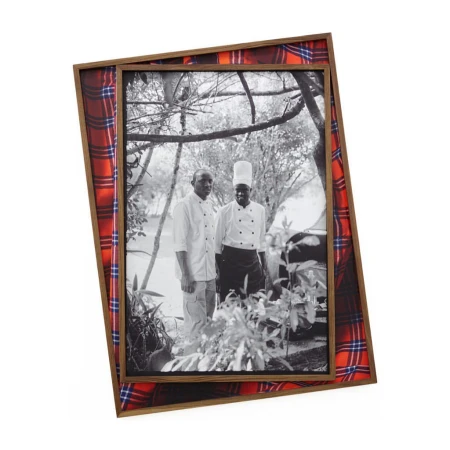 Framed black and white photograph of two men, one wearing a chef's hat, framed in a wooden frame with a red, blue, and white plaid fabric.