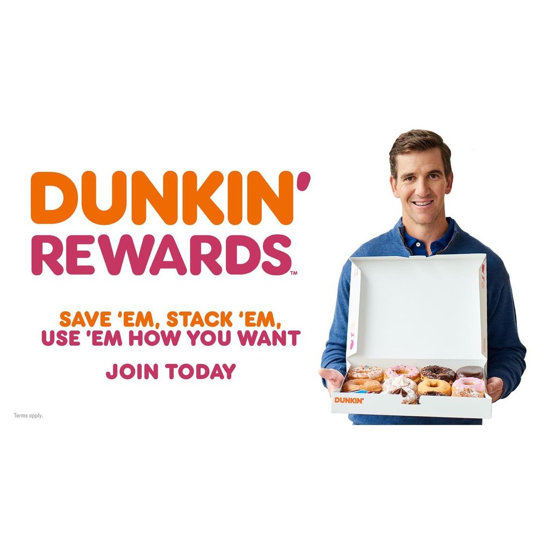 A Dunkin' Rewards advertisement featuring a man holding a box of donuts with Dunkin' Rewards branding on the left side of the frame.