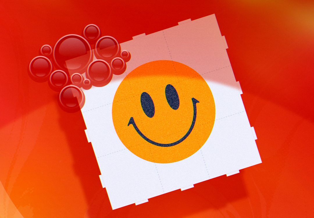 Orange smiley face on a white tile pattern against an orange background with red transparent spheres in the upper left corner.