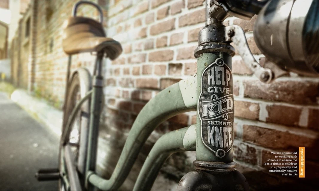 Close-up of a vintage-style bicycle with a weathered frame, leather seat, and brick wall backdrop, creating a nostalgic, artistic composition.