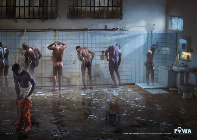 Group of nude men in a prison shower room standing in water, some washing, creating a gritty and unsettling visual narrative.