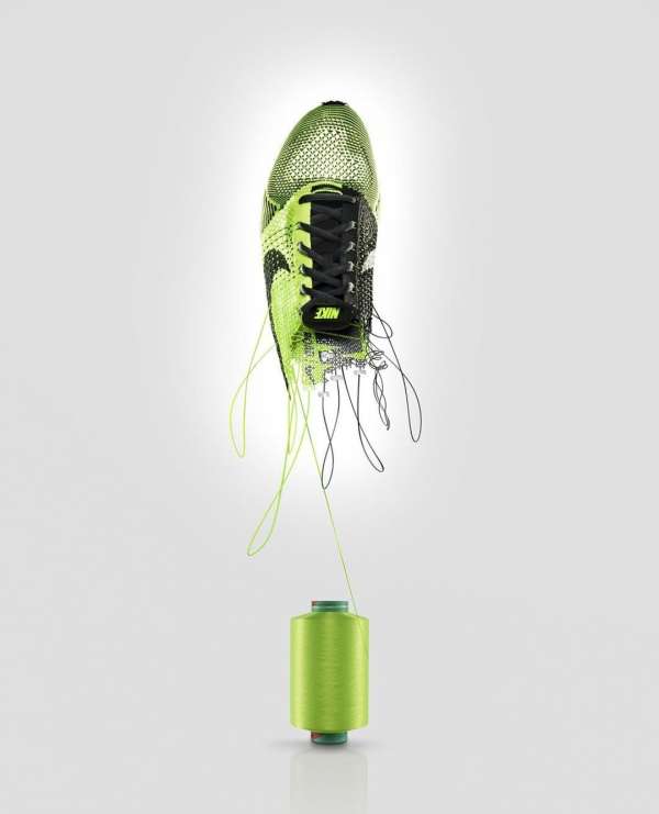 Nike running shoe floats above a lime green spool of thread against a gradient white background in a studio product shot.