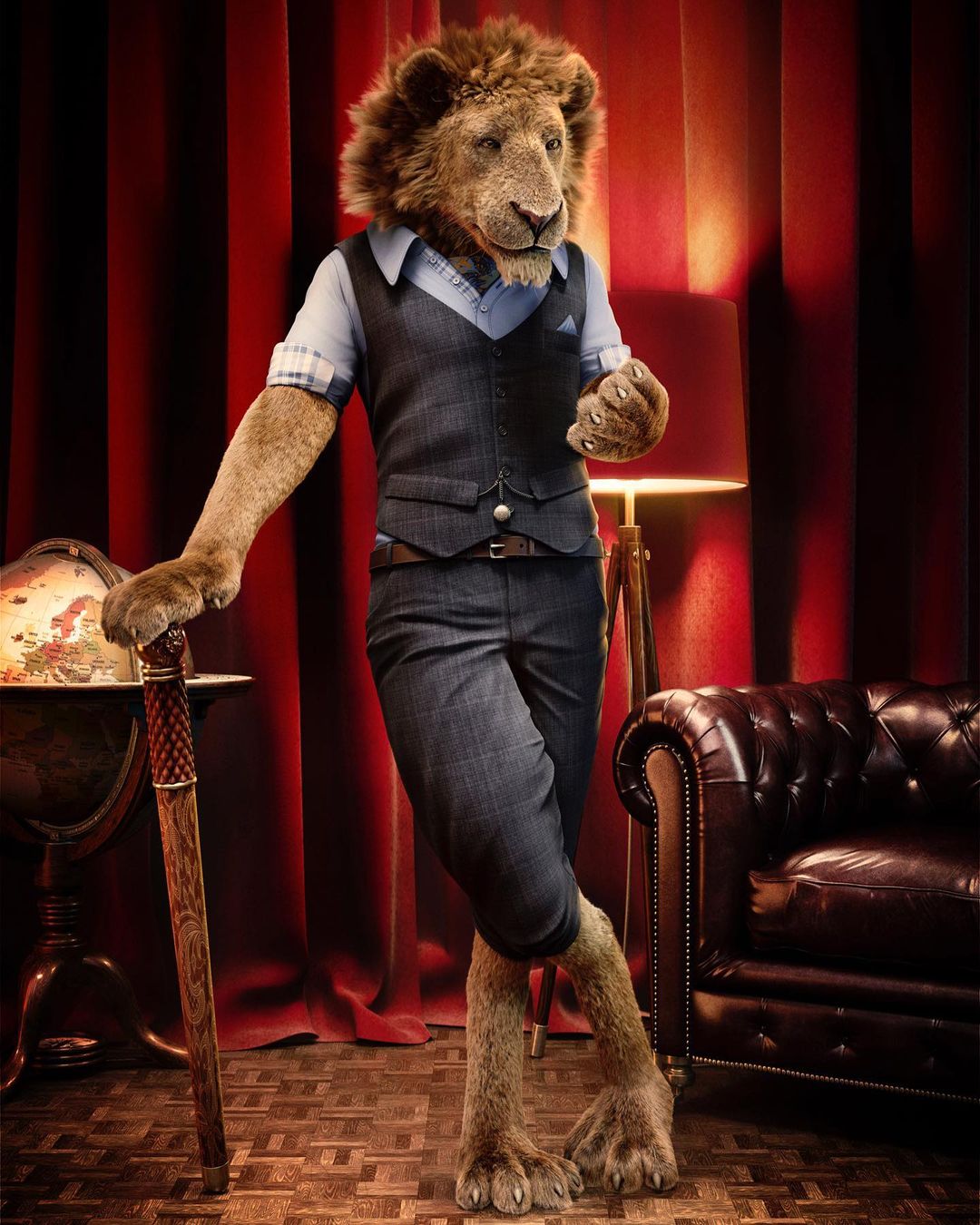 Anthropomorphic lion in suit standing indoors with red curtain backdrop, globe, and leather chair in an elegantly-lit setting.