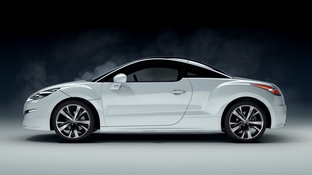Sleek white Peugeot RCZ coupe car with sporty alloy wheels in a studio setting. Automotive design showcasing elegance and performance.