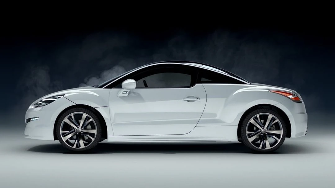 Sleek white Peugeot RCZ coupe car with sporty alloy wheels in a studio setting. Automotive design showcasing elegance and performance.