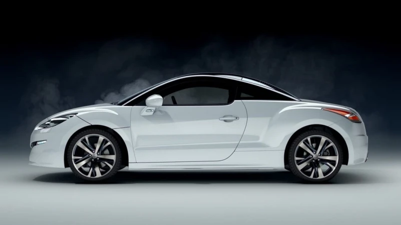 Sleek white Peugeot RCZ coupe car with sporty alloy wheels in a studio setting. Automotive design showcasing elegance and performance.