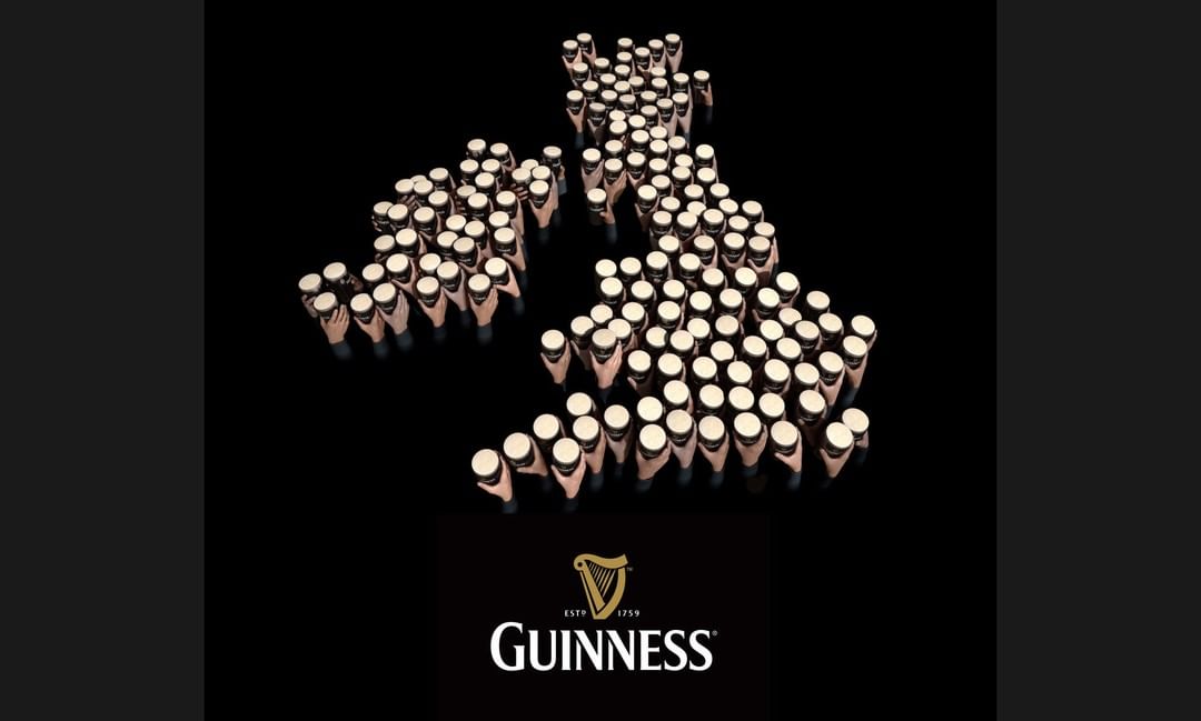 Conceptual image forming the United Kingdom map with Guinness beer pints; dark background and the beer brand logo is visible.