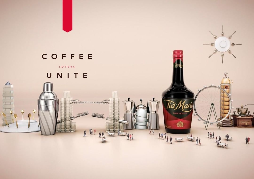 Tia Maria dark liquor bottle with coffee, beverage, and dessert elements displayed in a whimsical studio setting on a tan background.