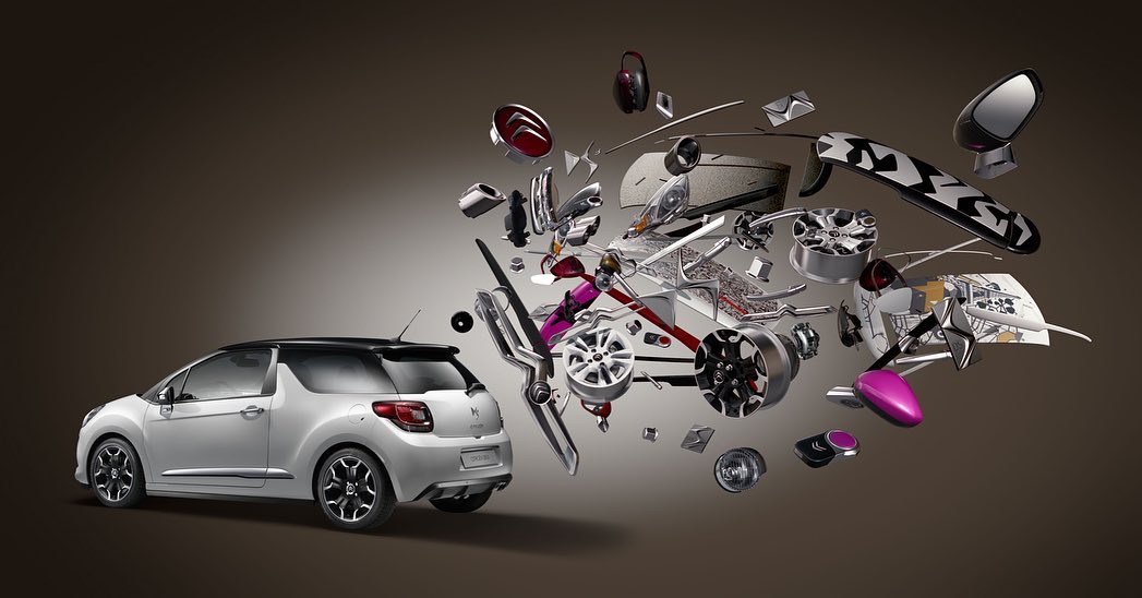 Automotive product shot features a white compact car with separated car parts floating near it against a gradient gray background.
