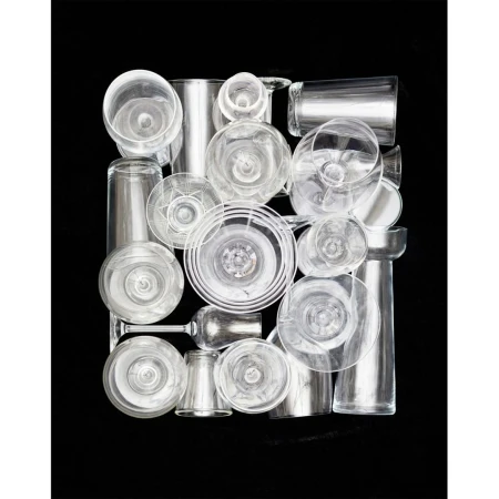 Arrangement of various clear glass drinkware on a black backdrop, creating a minimalist and modern composition with transparent textures.