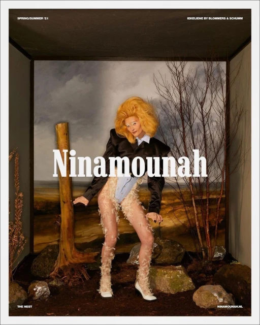 Fashion editorial shot of a stylish woman in a faux fur outfit posing in a box-like studio setting with a painted backdrop and props.