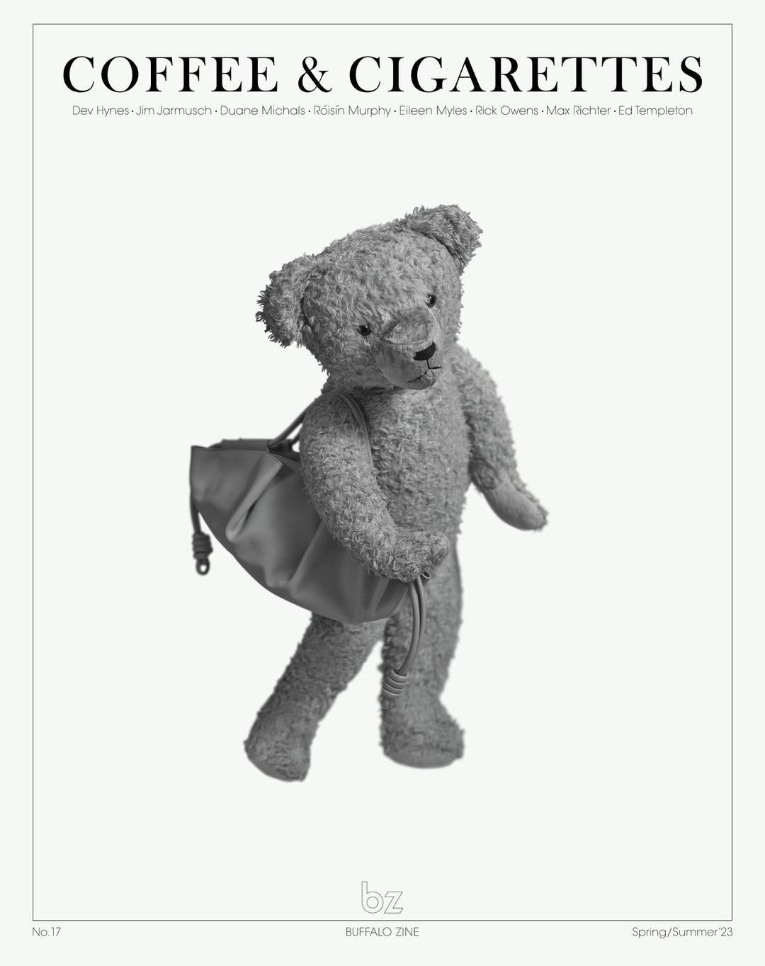 Black and white studio shot of a teddy bear figure carrying a duffel bag against a light backdrop with magazine cover text.