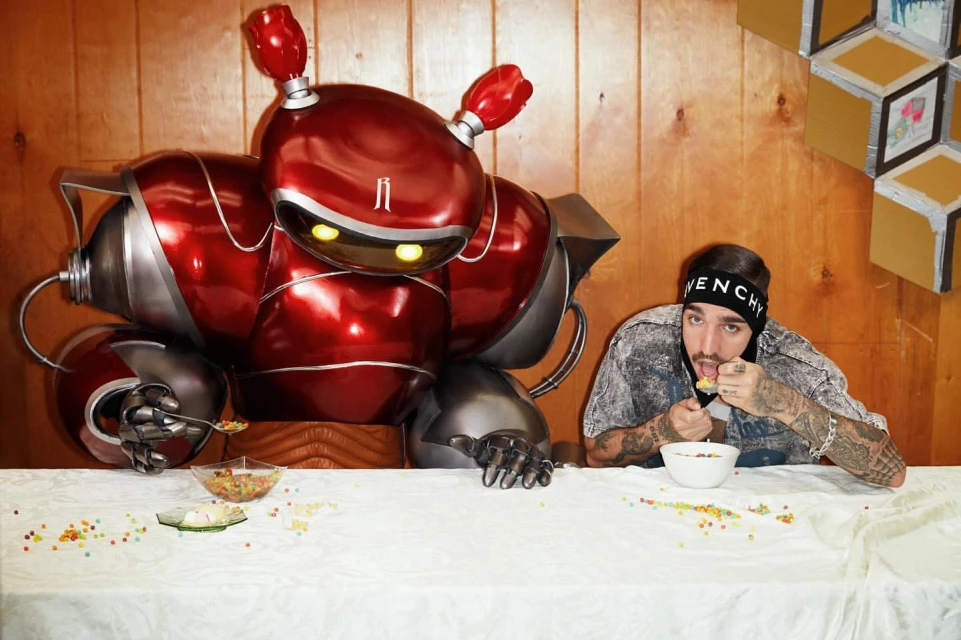 Man in a headband eats cereal at a white table with a large red robot figure, set against a wood paneled wall with geometric decor.