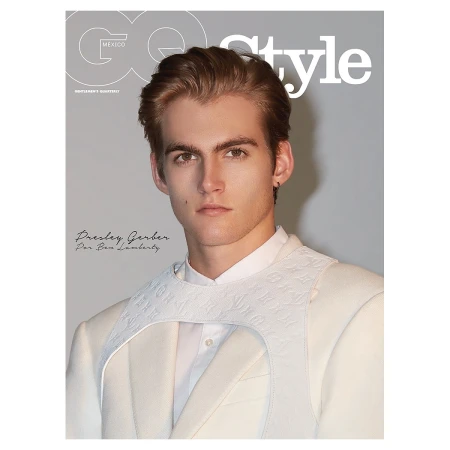 Portrait of a young male model with styled brown hair wearing a white shirt and white embossed harness by photographer Ben Lamberty
