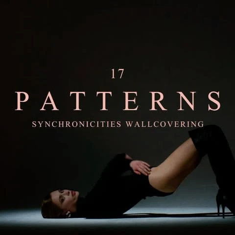 Woman in black bodysuit and boots poses on floor against dark background with 'Patterns Synchronicity Wallcovering' text overlay.