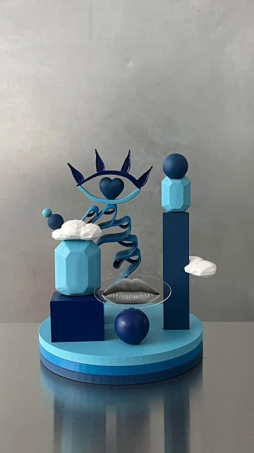 Abstract art still life features geometric shapes, eye design, lips on glass, and ball on striped platform against a silver background.